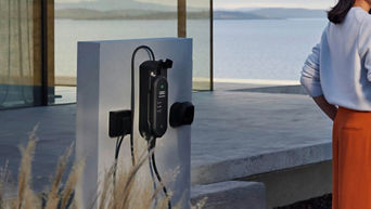 An EV charger mounted on an outside white wall