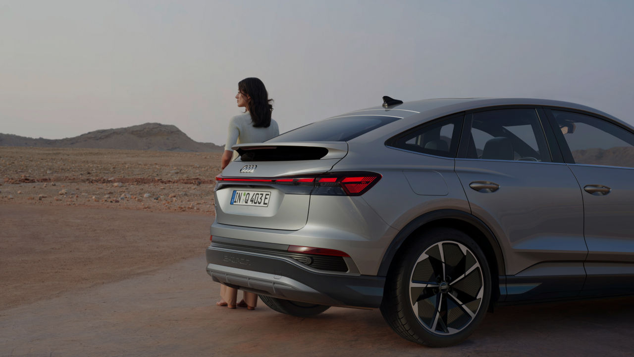 A man and woman stand beside a parked car, smiling and enjoying their time together outdoors.