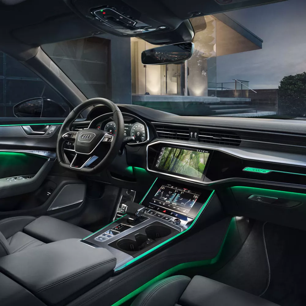 Luxurious Audi interior featuring sleek design, modern touchscreen displays, ambient green lighting, and premium leather seating.