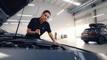 A man repairing a car with tools in hand