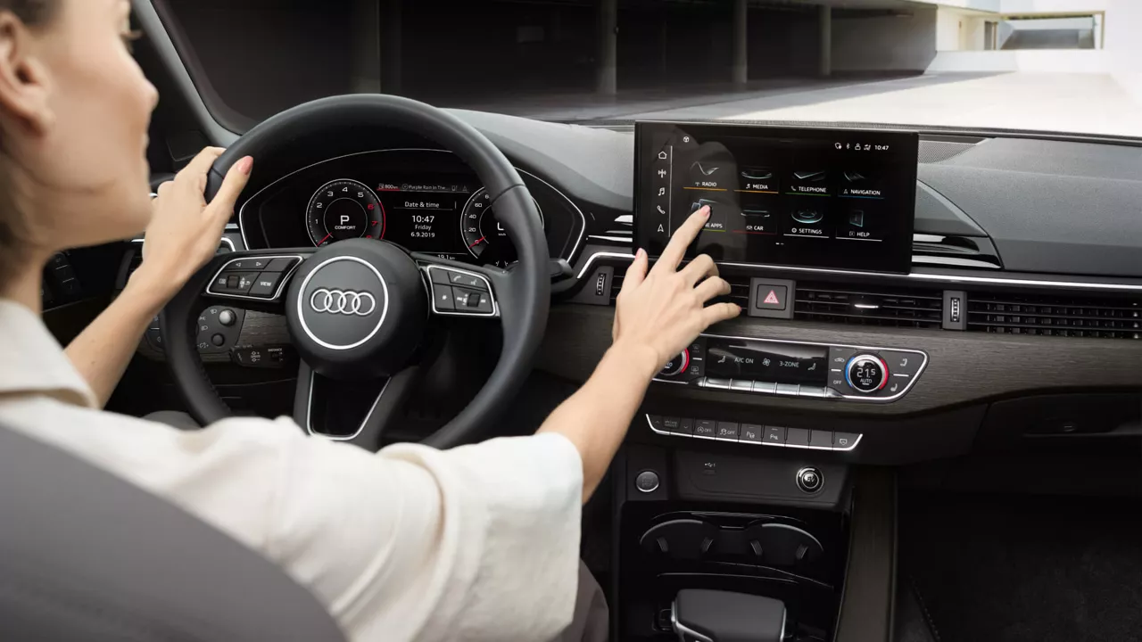 A female driver interacting with the digital dashboard in an Audi A4