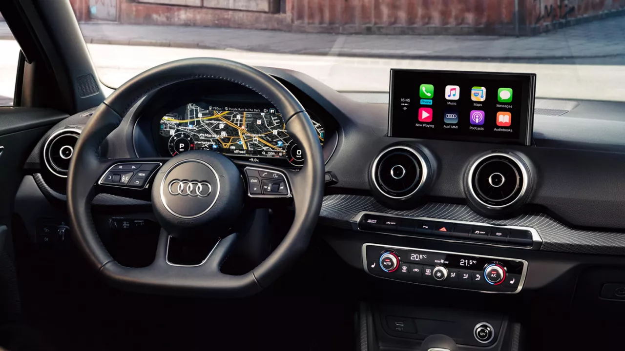 The interior of an Audi Q2 with the focus on the dashboard and steering wheel 