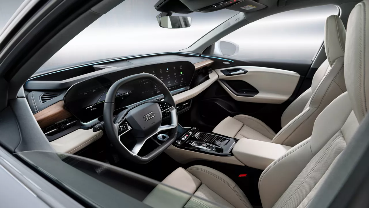 The front interior of an Audi Q6 e-tron with the steering wheel, dash and both seats in view