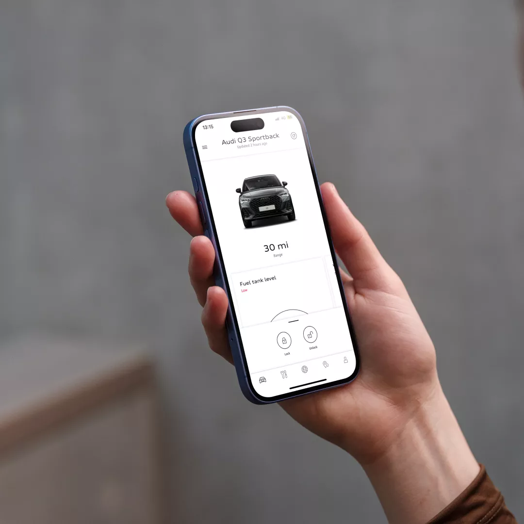 Hand holding up a mobile phone with myAudi app visible on its screen
