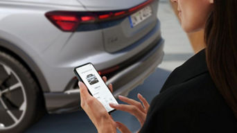 Person holding their mobile phone and interacting with the myAudi app