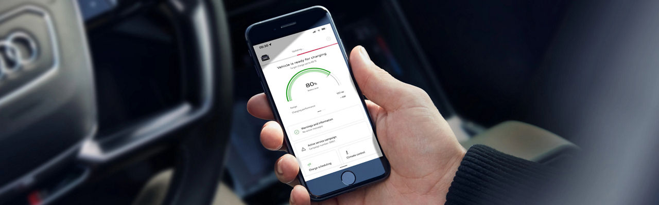  A hand holding a mobile phone that is displaying the myAudi app
