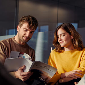 A man and a woman reading from a booklet