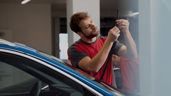 A man repairing a car with tools in hand