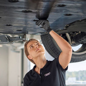A mechanic sitting in a car while looking at a computer screen