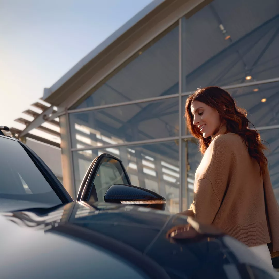 A woman standing next to a car