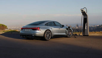 A grey e-tron GT parked and plugged into an EV charger