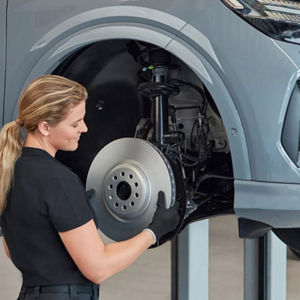 A woman changing a car's breaks
