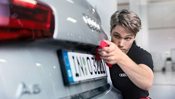 An Audi mechanic inspecting the rear of an Audi vehicle