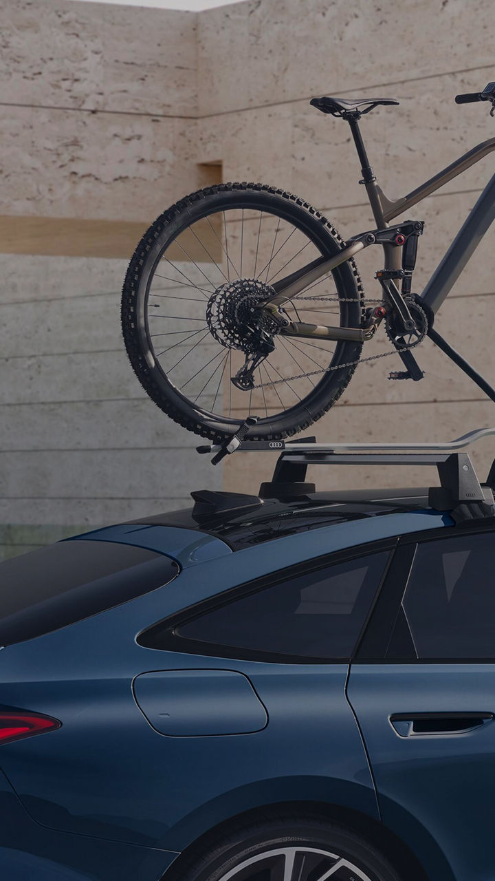 An Audi car with a bicycle mounted on its roof