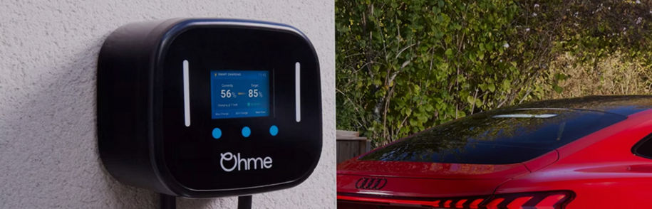 EV charging station with display, cable, and a blurred electric Audi vehicle in the background