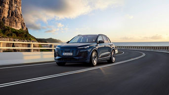 Audi Q6 e-tron travelling along an open coastal road