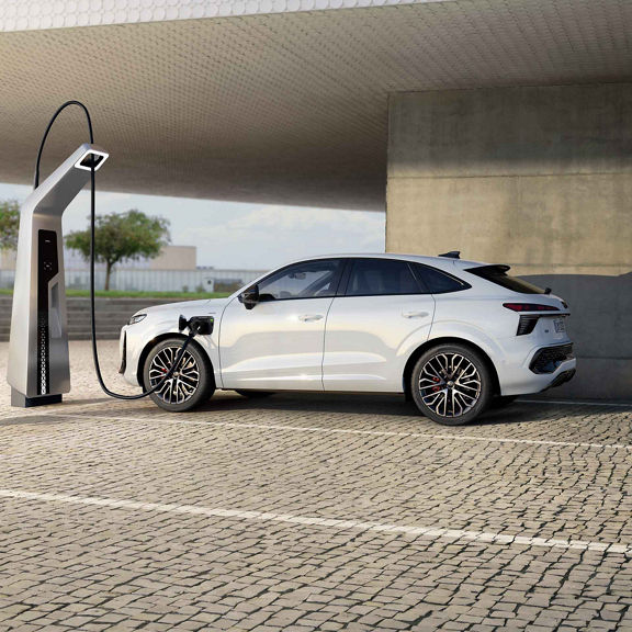 Audi Q3 Sportback e-hybrid Laden an einer öffentlichen Ladesäule auf einem Parkplatz.