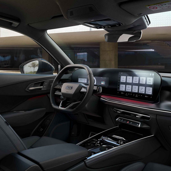 Die Abbildung zeigt den Innenraum des Audi Q3 Sportback e-hybrid. Zu sehen ist das Panorama-Display. Zu sehen sind auch die rot beleuchteten Instrumente.