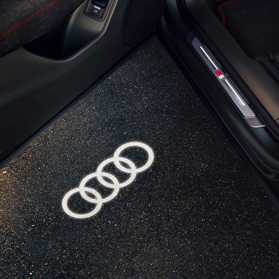 Audi Q3 Sportback illumina il terreno dalla portiera con luci LED. Gli anelli Audi sono visibili.