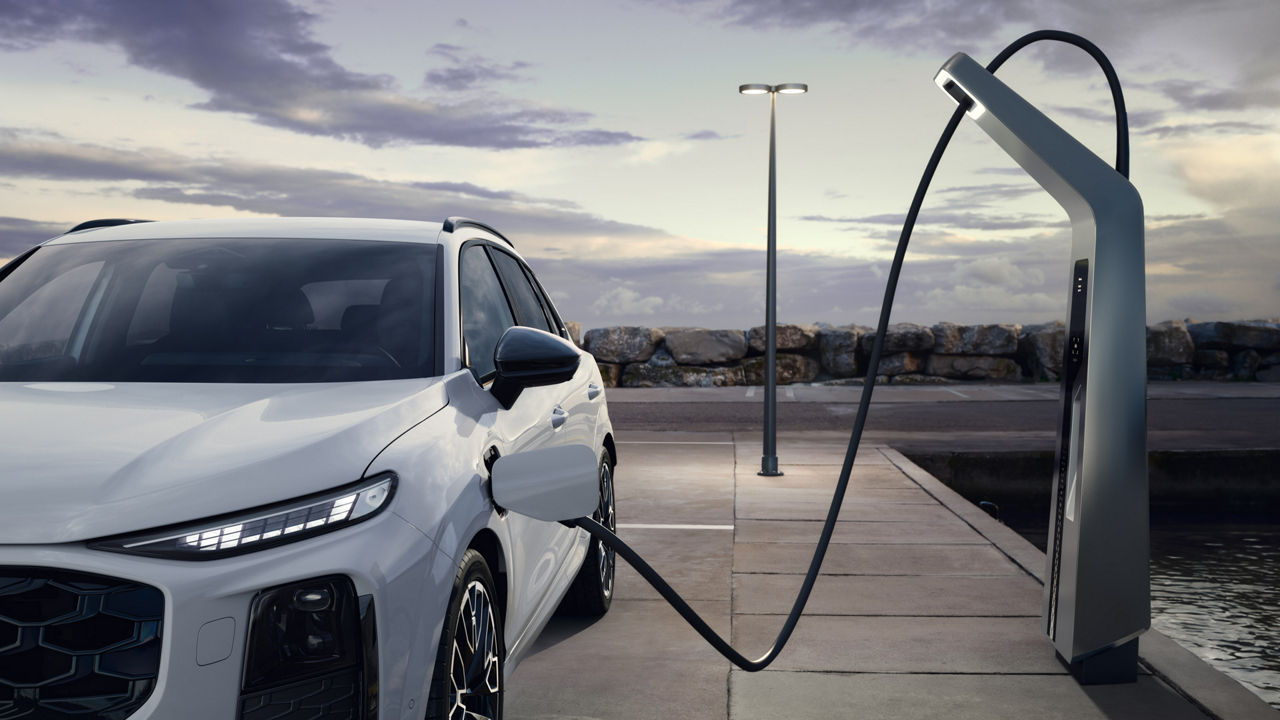 Audi Q3 SUV e-hybrid auf einem Parkplatz aufladen
