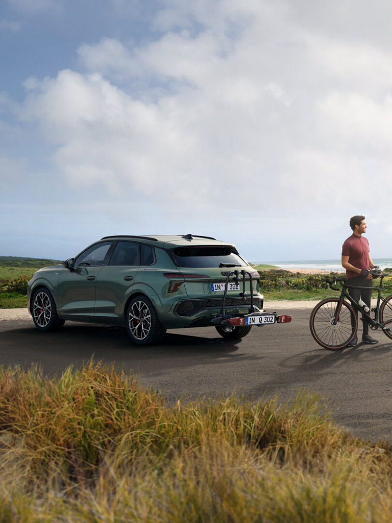 Audi Q3 SUV AOZ Rückansicht mit Fahrradträger und Personen davor