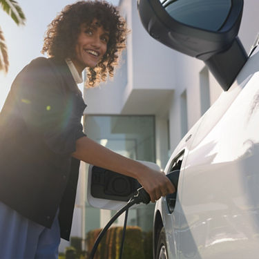Audi Q3 SUV e-hybrid Eine Dame, die das Auto auflädt