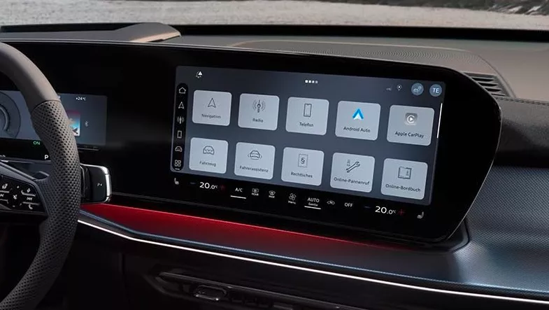 Das Auto-Armaturenbrett verfügt über einen prominenten Infotainment-Bildschirm, auf dem verschiedene Fahrzeugfunktionen und -anwendungen wie Navigation, Radio und Fahrzeugeinstellungen angezeigt werden.  Die Klimasteuerung ist digital in den Bildschirm integriert, mit Temperatureinstellungen sowie Tasten für Klimaanlage, Fond, Max, Auto und Aus.  Das Armaturenbrett umfasst außerdem physische Bedienelemente am Lenkrad, eine Umgebungsbeleuchtung und ein kleineres Display, das die Geschwindigkeit und den Gang des Fahrzeugs anzeigt.
