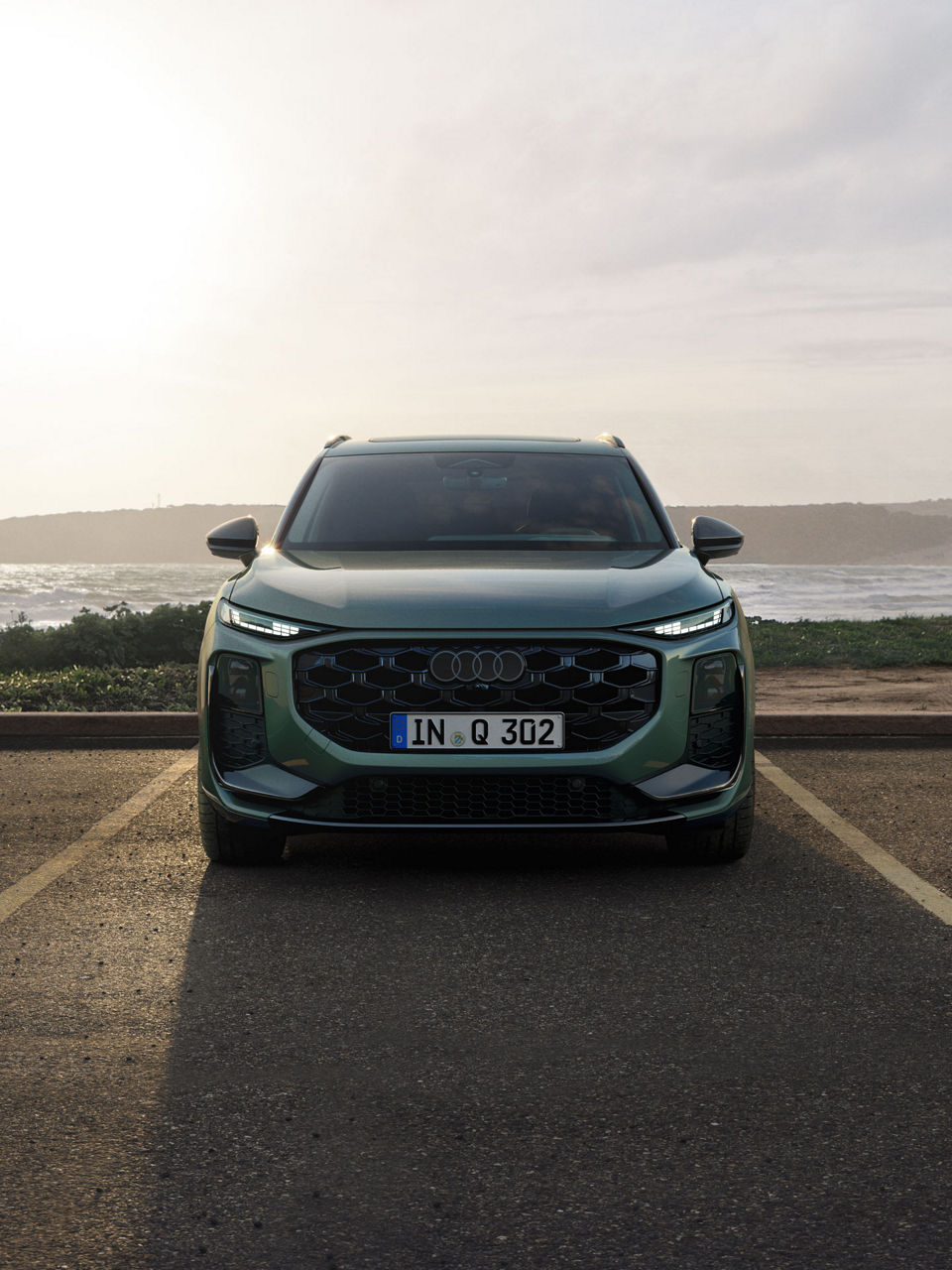 Audi Q3 SUV front view, parking in front of the water.