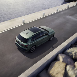 Q3 SUV kör på en väg parallellt med havet.