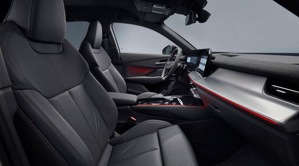 Främre interiören i Audi Q3 SUV med röd ambientbelysning, upphöjda säten och panoramadisplay.