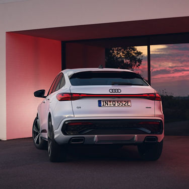 Audi Q5 Sportback e-hybrid rear view in a parking lot in the evening