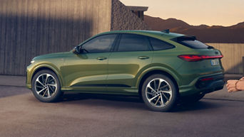 Grüner Q5 Sportback steht vor einem modernem Gebäude, im Hintergrund sind Berge zu sehen.