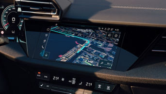 Frau blickt auf das digitale Navigationsdisplay im Audi-Lenkrad mit eingeblendeter Straßenkarte.