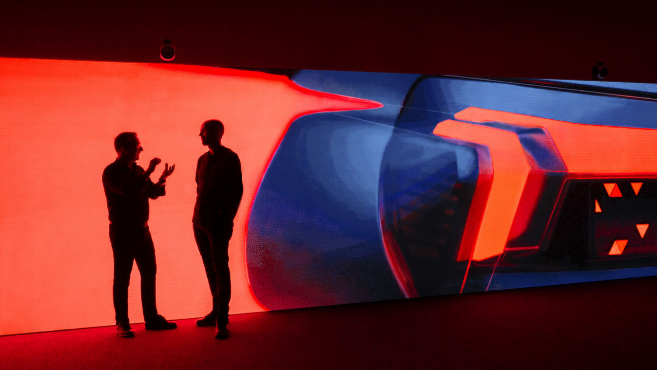 Zwei Audi Designer diskutieren vor einer Lichtprojektion
