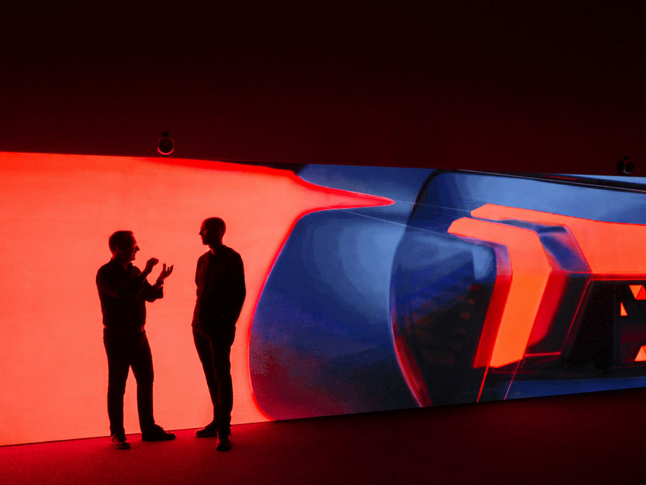 Zwei Audi Designer diskutieren vor einer Lichtprojektion