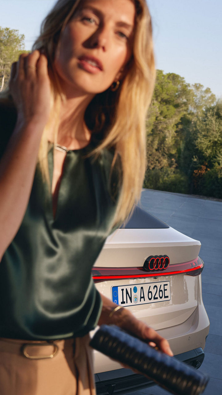 Audi A6 Sportback e-tron woman in front of the Audi A6 Sportback e-tron
