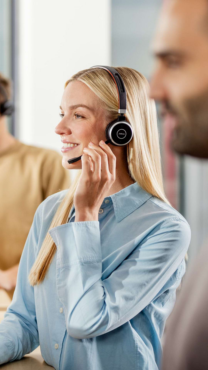 A woman with blonde hair talking via a wireless headset