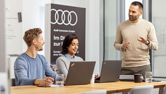 Eine Frau und ein Mann stehen hinter einem Audi Q5 Modell