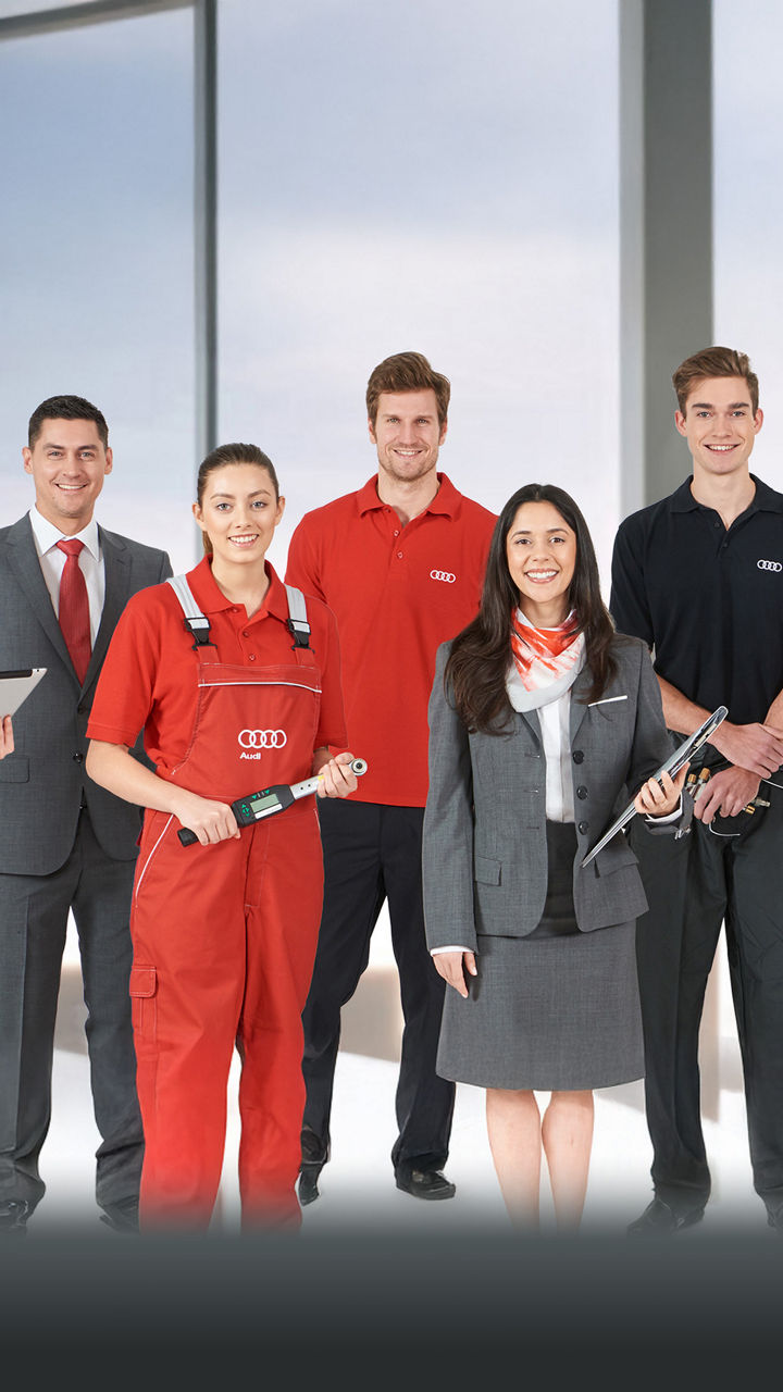 Gruppenbild eines Teams aus verschiedenen Bereichen des Autohauses, alle in ihrer entsprechenden Arbeitskleidung