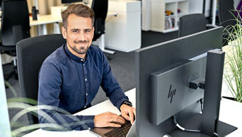 Markus, Product Manager SCD, sits at his laptop and laughs into the camera