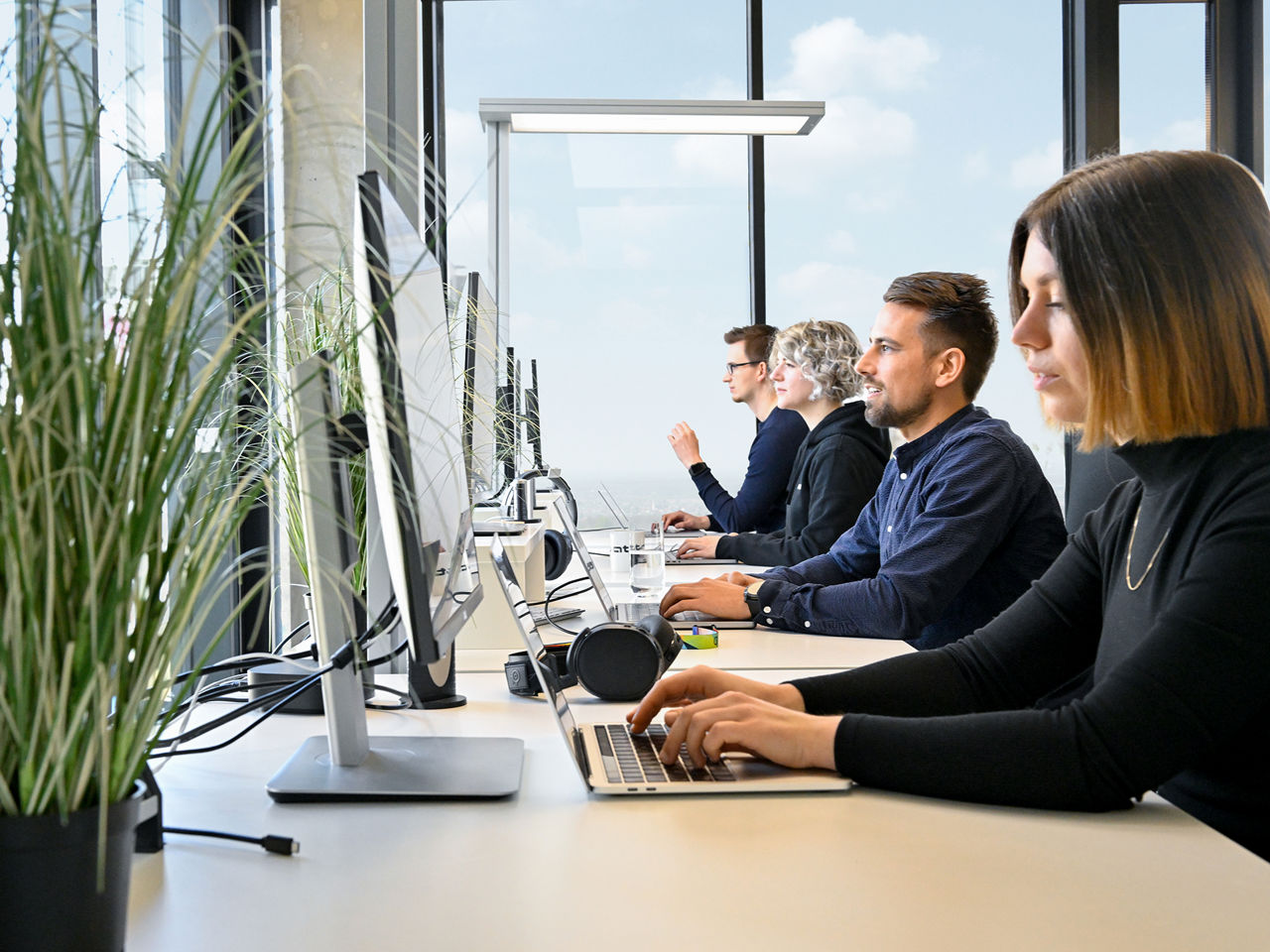 Employees of the Audi Software Development Center are at work and have laptops in front of them