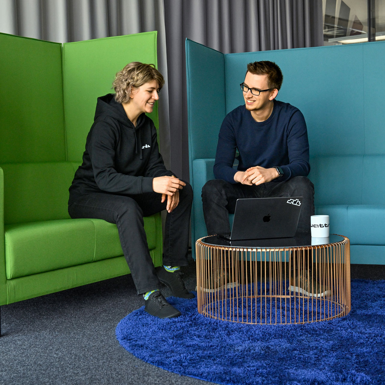 Nadine and a colleague from the SDC sit on benches and are in conversation