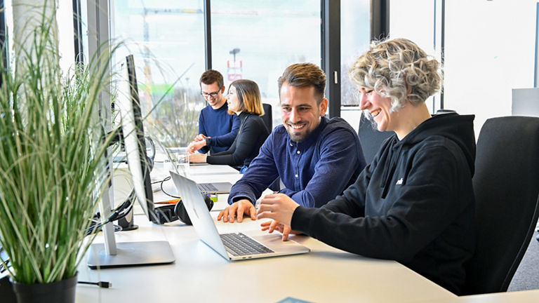 Markus, Product Manager SCD, schaut mit einer Kollegin auf einen Laptop