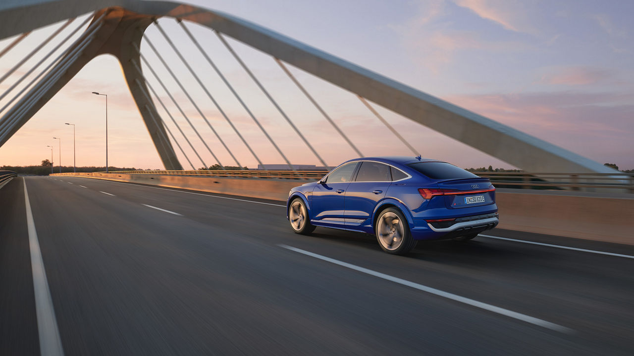 Blue Audi SQ8 Sportback e-tron drives over a bridge