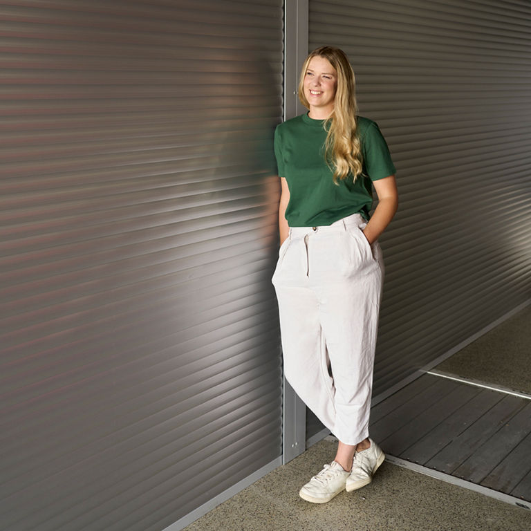 Lissi Lanz has her hands in her pockets and is leaning on a wall