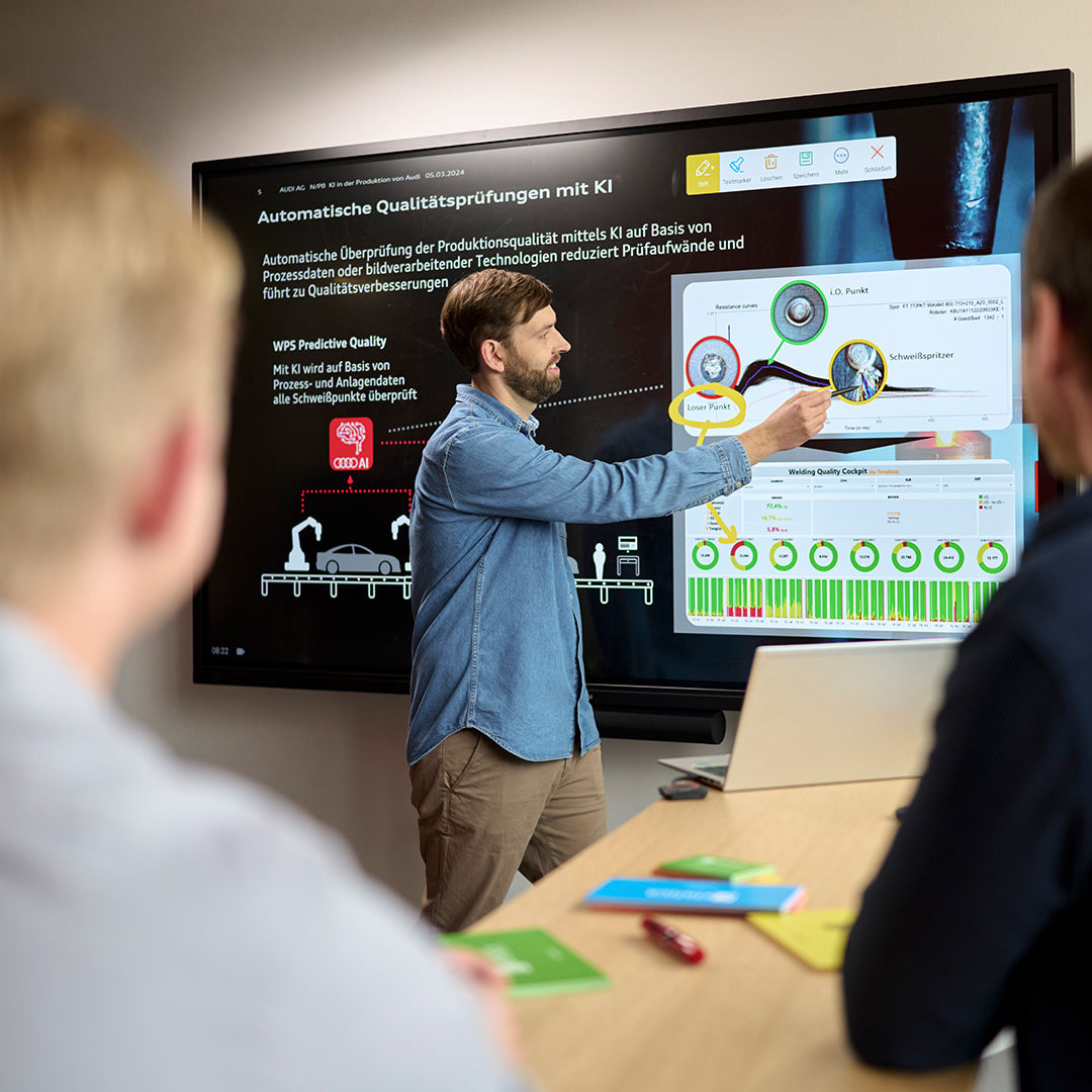 Andreas shows his team something on a blackboard