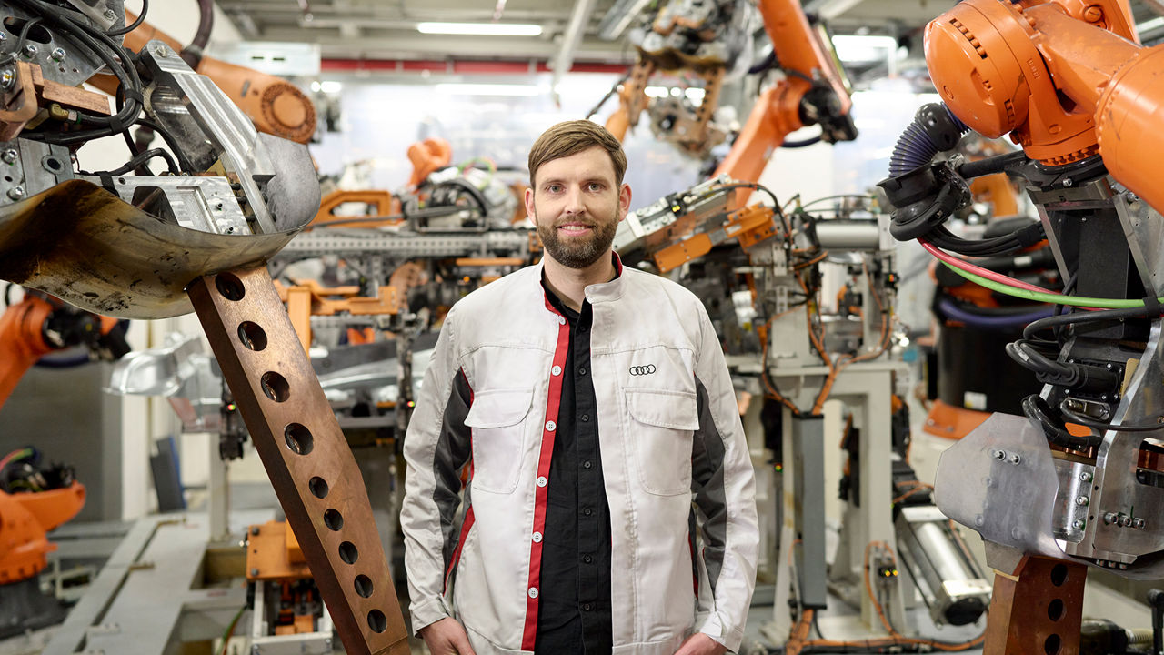 Andreas Kühne zeigt einer Kollegin ein Gerät in der Produktion und Logistik bei Audi