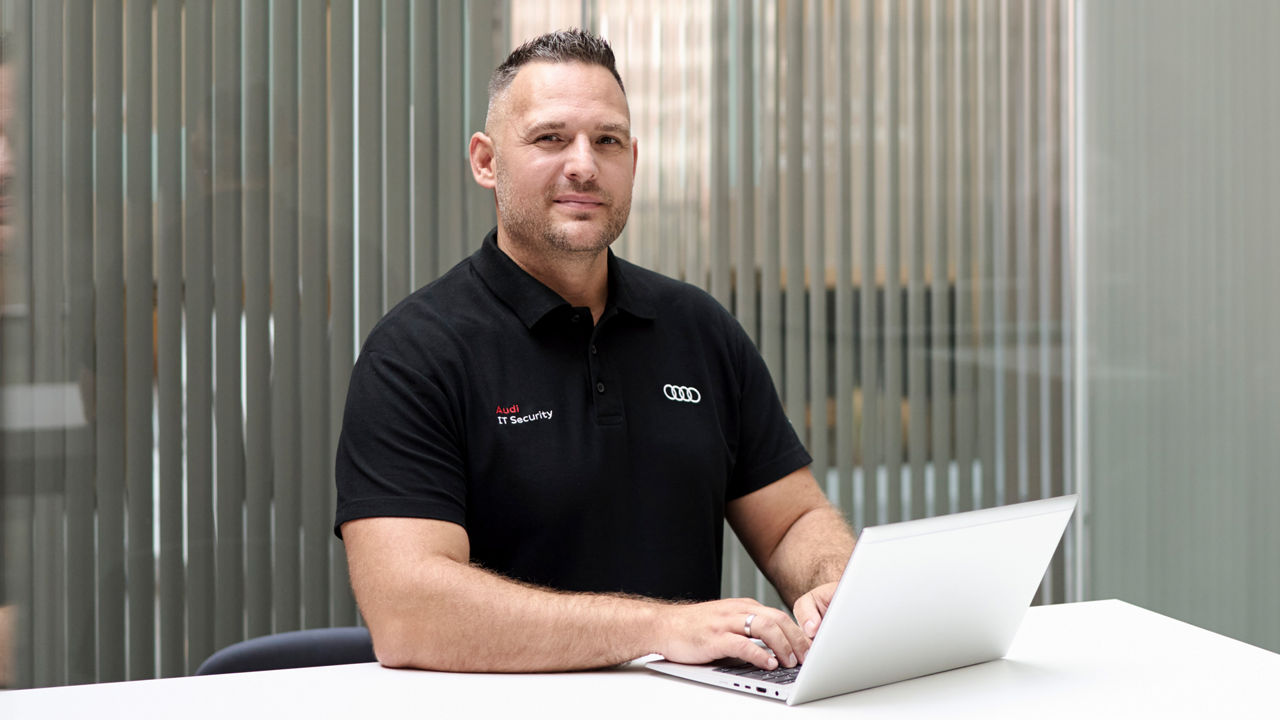 Andreas Walter schaut in die Kamera und hat einen Laptop vor sich
