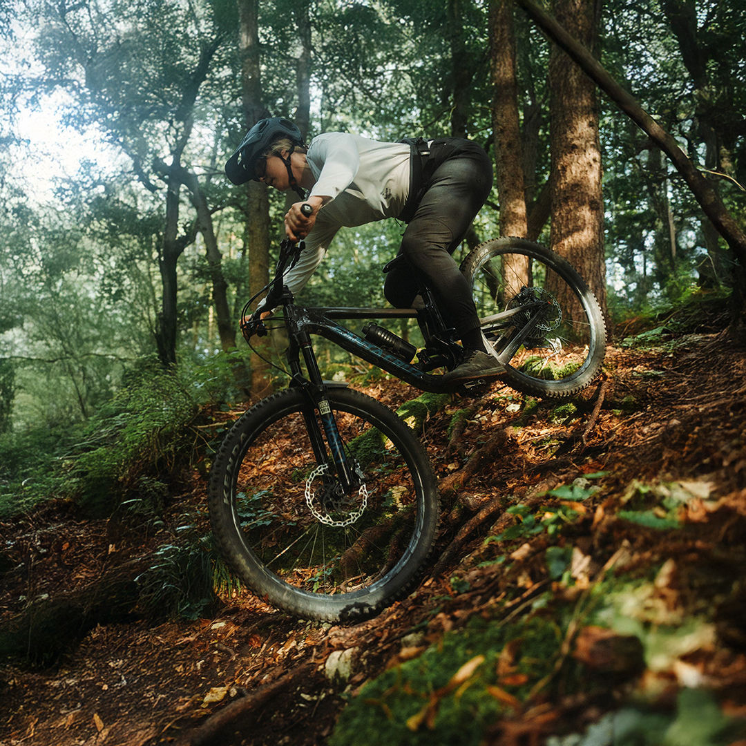 Lissi Lanz fährt mit ihrem Mountainbike durch einen Wald einen Berg herunter