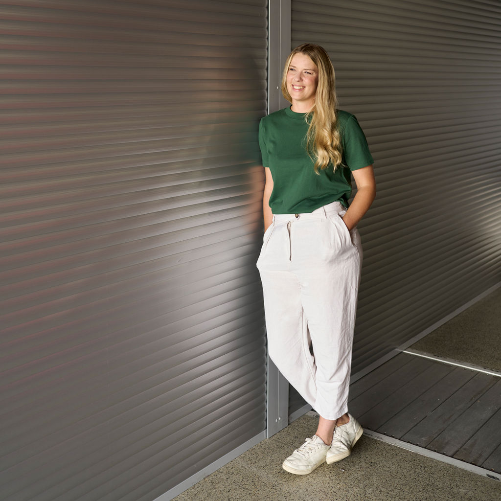 Lissi Lanz hat ihre Hände in den Hosentaschen und ist an eine Wand gelehnt